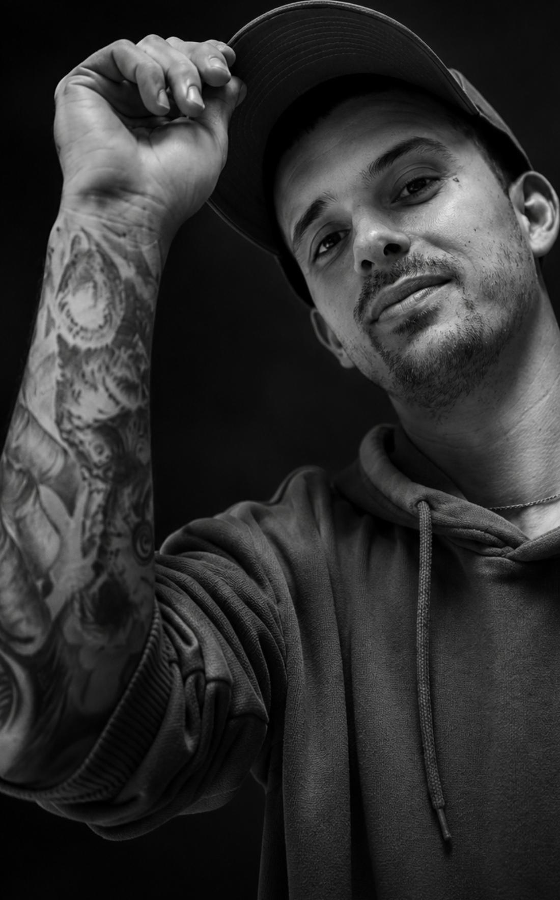 Manuel Carmona, tatuador de Mono Tattoo, con gorra y el brazo tatuado